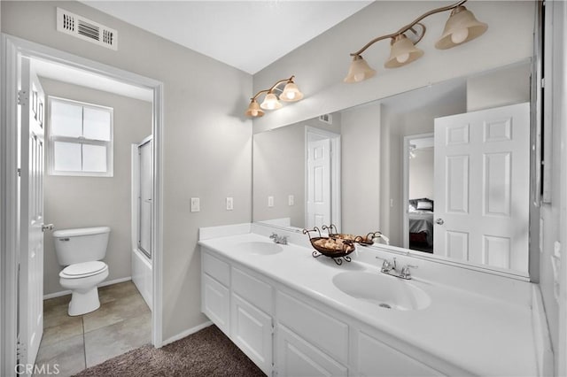 ensuite bathroom featuring shower / bath combination with glass door, tile patterned flooring, visible vents, and a sink