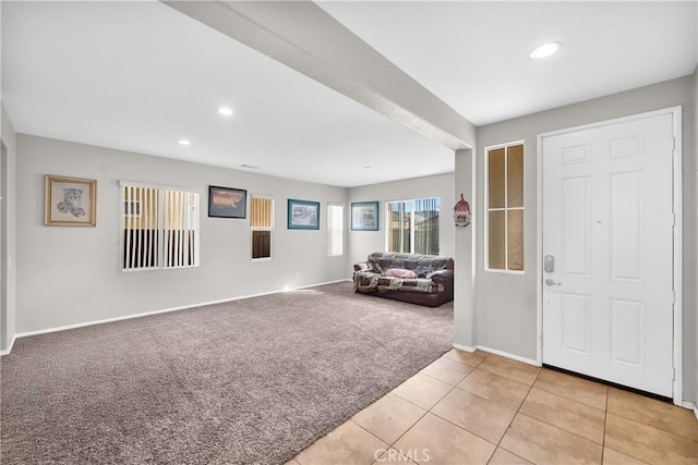 entryway with recessed lighting, light carpet, baseboards, and light tile patterned flooring