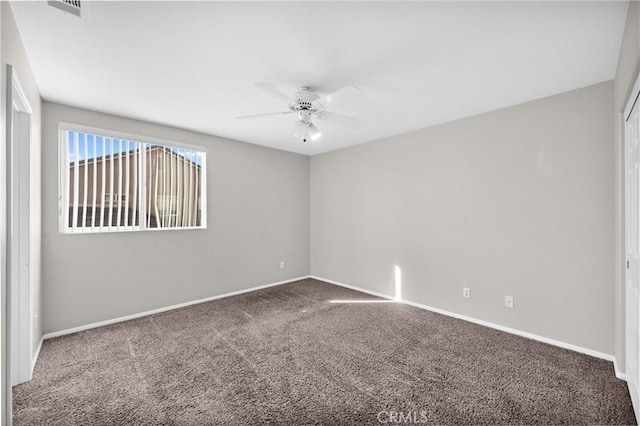 carpeted empty room featuring ceiling fan, visible vents, and baseboards