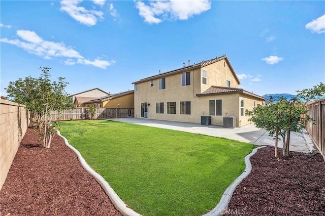 back of property with a lawn, a patio area, and a fenced backyard