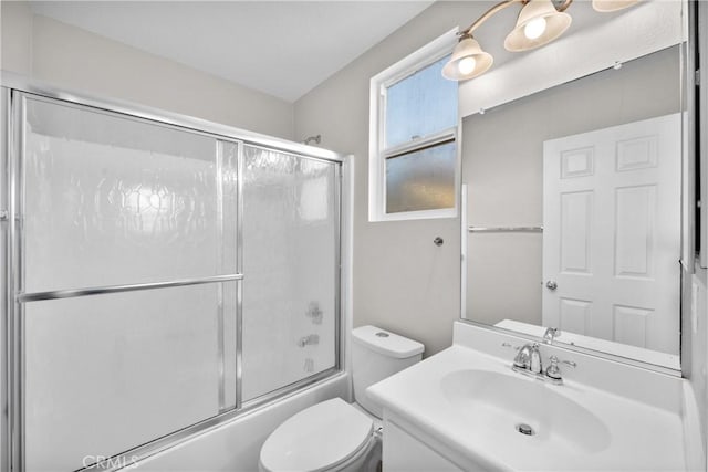 full bath featuring combined bath / shower with glass door, vanity, and toilet