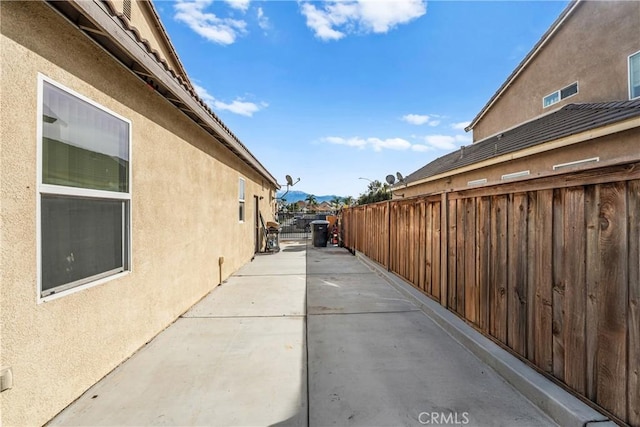 view of property exterior featuring fence, a patio, and stucco siding