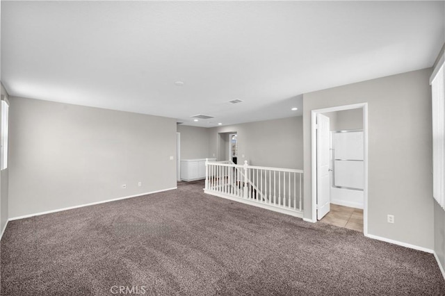 empty room with baseboards, recessed lighting, and light colored carpet