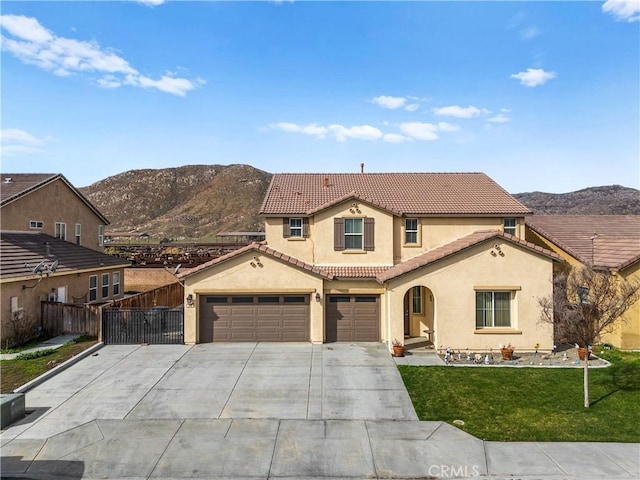 mediterranean / spanish home featuring a tile roof, fence, a front yard, a mountain view, and stucco siding