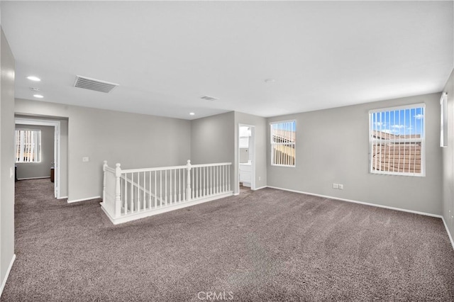 spare room featuring dark colored carpet, recessed lighting, visible vents, and baseboards