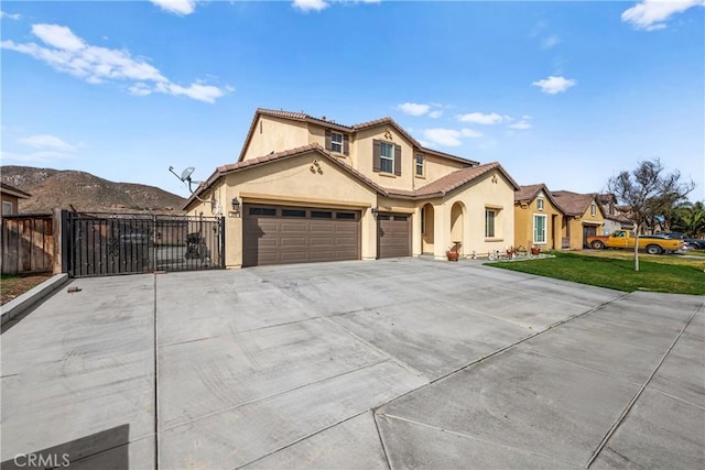 mediterranean / spanish house with driveway, a tiled roof, fence, a front yard, and stucco siding