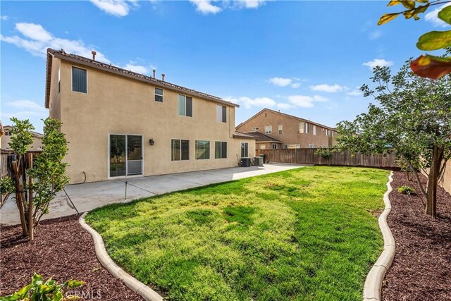 rear view of property featuring a patio, a yard, and a fenced backyard