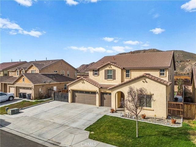 mediterranean / spanish house with a residential view, a tiled roof, fence, a front yard, and stucco siding