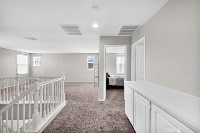 hall featuring a wealth of natural light, carpet flooring, an upstairs landing, and visible vents