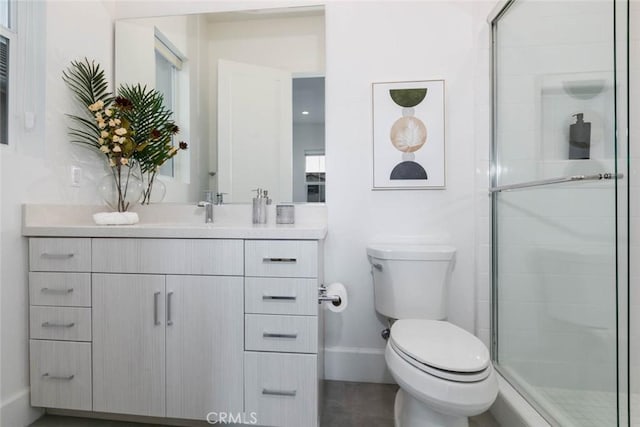 bathroom featuring vanity, an enclosed shower, and toilet