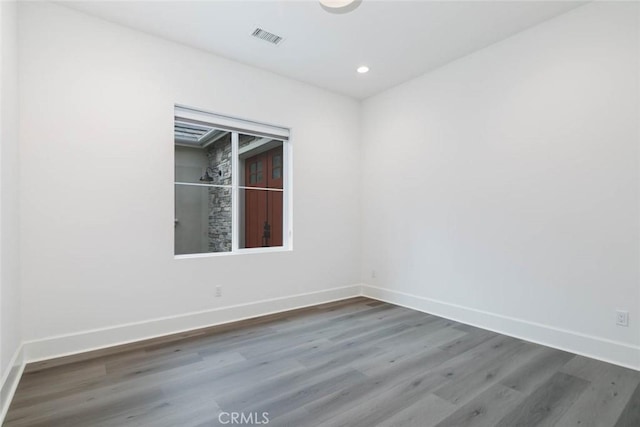 unfurnished room with wood-type flooring