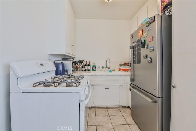 kitchen with white cabinetry, white gas range, stainless steel fridge, and sink