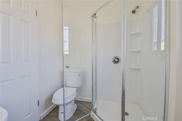 bathroom featuring wood-type flooring, toilet, and walk in shower