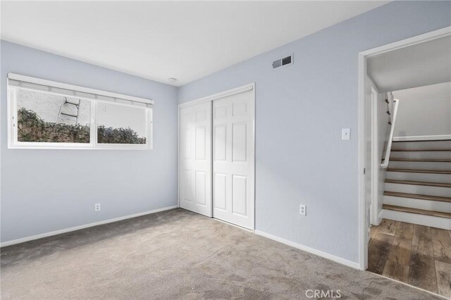 unfurnished bedroom featuring carpet floors and a closet