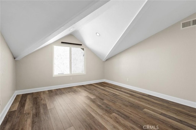 additional living space featuring dark wood-type flooring and lofted ceiling