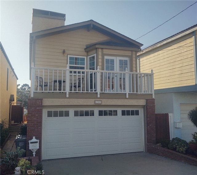 view of front of property featuring a balcony and a garage