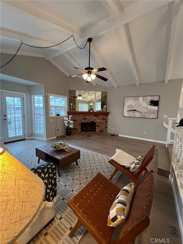 living room featuring lofted ceiling with beams, hardwood / wood-style floors, and a fireplace