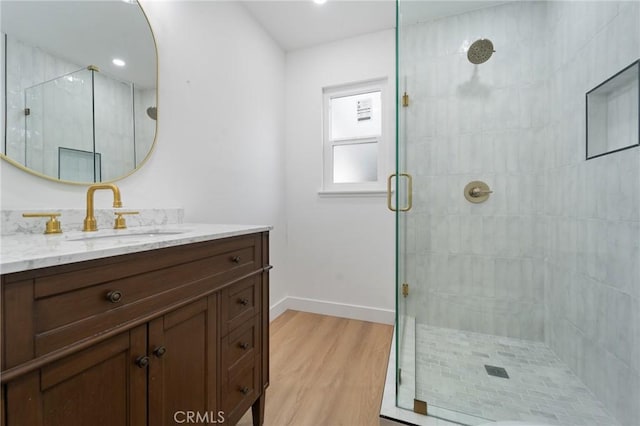 bathroom with vanity, hardwood / wood-style floors, and a shower with door