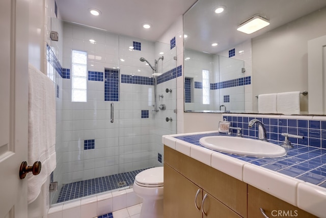 bathroom with backsplash, tile patterned flooring, vanity, an enclosed shower, and toilet