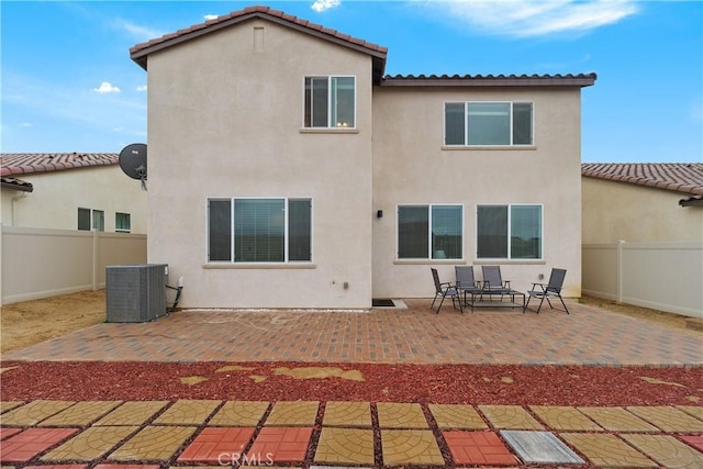 back of house with stucco siding, central AC, and a patio area