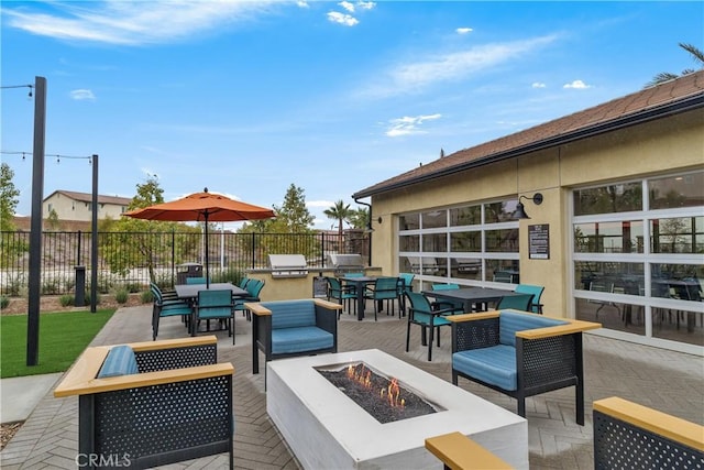 view of patio / terrace featuring an outdoor living space with a fire pit, outdoor dining space, and fence