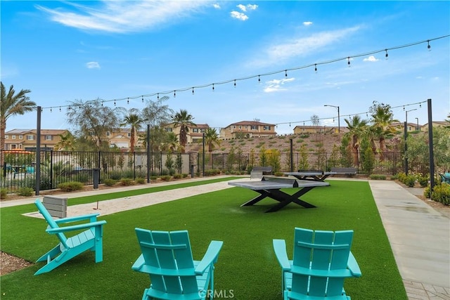 view of community with a lawn and fence