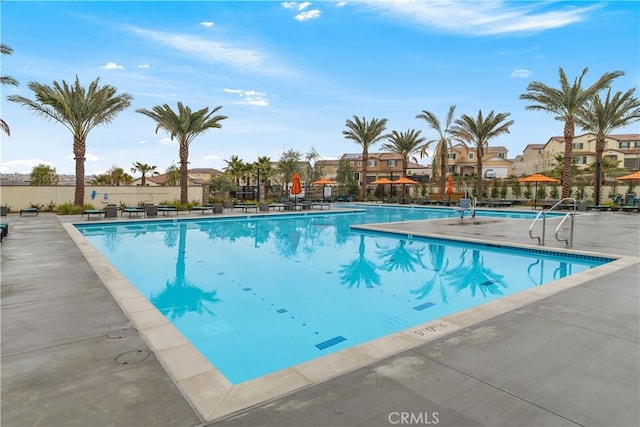 community pool with a residential view and a patio