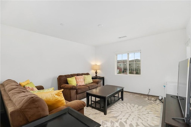 living area with visible vents and light carpet