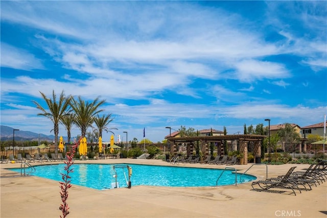 pool with a patio area, fence, and a pergola