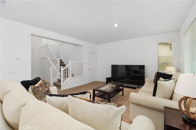 carpeted living area with recessed lighting and stairway