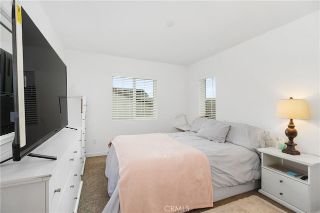 bedroom with baseboards and light carpet