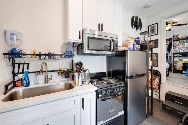 kitchen with ceiling fan, white cabinetry, black range with electric cooktop, and sink