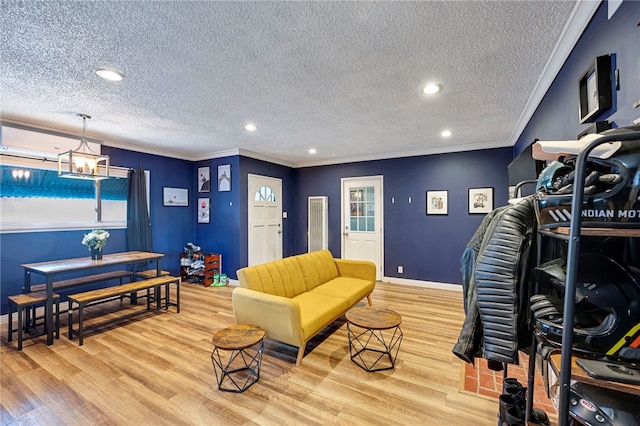 living room with light wood-type flooring, crown molding, and a textured ceiling