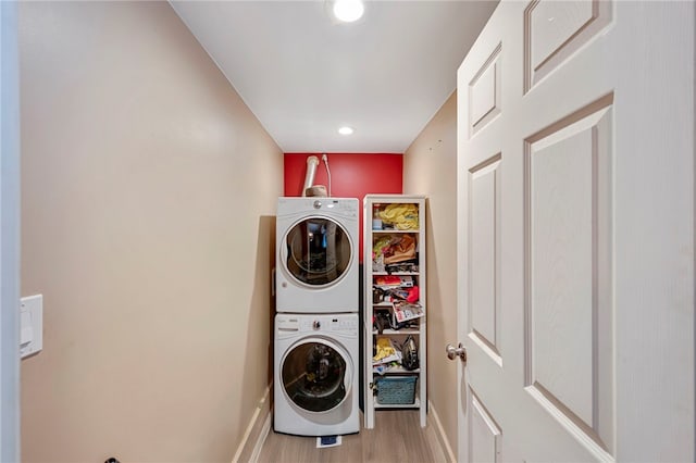 clothes washing area featuring stacked washer / dryer and light wood-type flooring