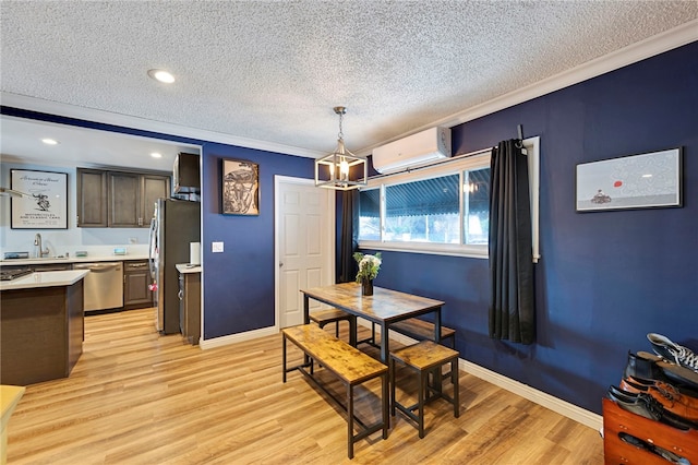 dining space with an AC wall unit, a textured ceiling, crown molding, light wood-type flooring, and an inviting chandelier