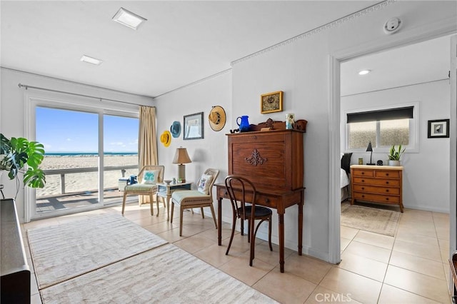 living area with a water view, plenty of natural light, and light tile patterned floors