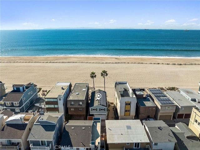 birds eye view of property with a water view and a beach view