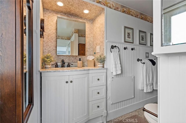 bathroom with vanity, backsplash, and toilet