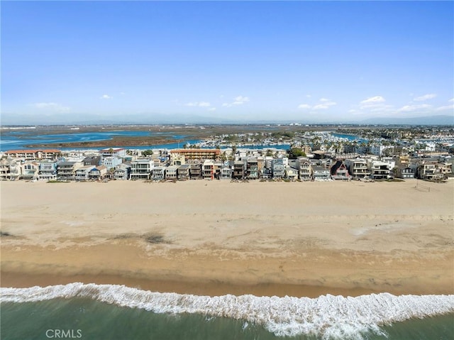 birds eye view of property with a water view and a beach view