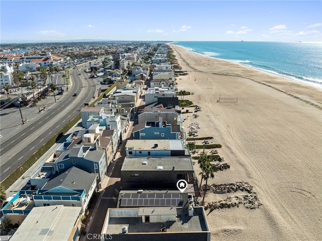 birds eye view of property with a water view and a beach view