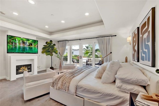 carpeted bedroom featuring a raised ceiling, access to exterior, and french doors