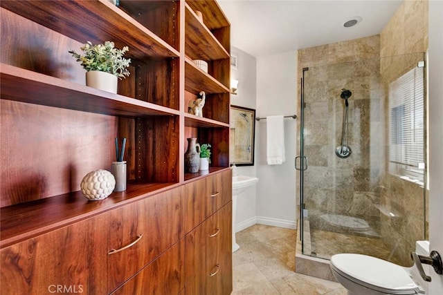 bathroom with a shower with shower door and toilet