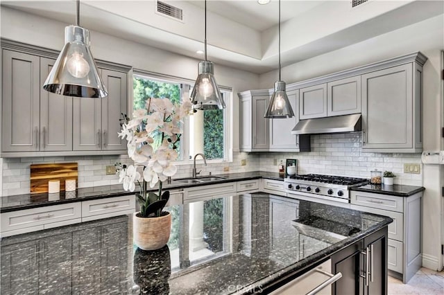 kitchen featuring decorative light fixtures, gray cabinets, sink, and dark stone countertops