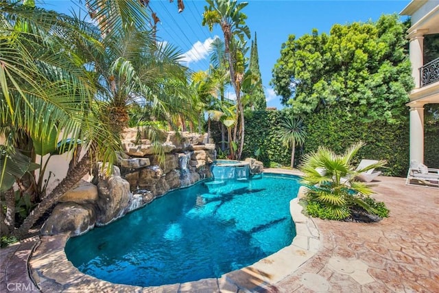 view of swimming pool featuring pool water feature and a patio area