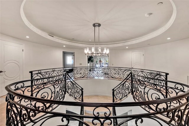 interior space with a chandelier, a raised ceiling, and light tile patterned flooring