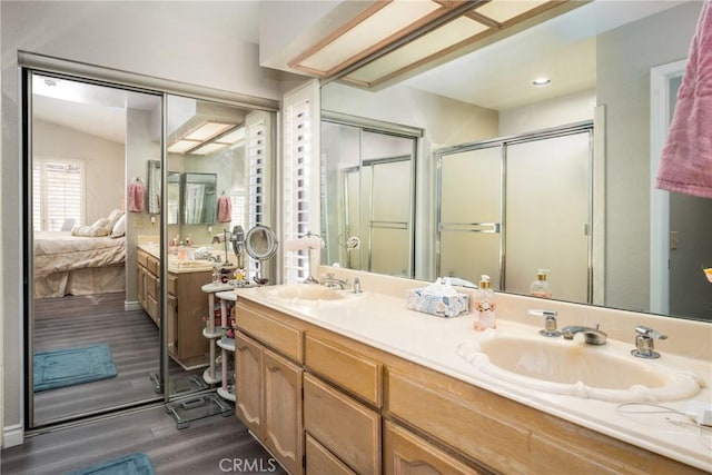 bathroom with hardwood / wood-style flooring, vanity, and an enclosed shower