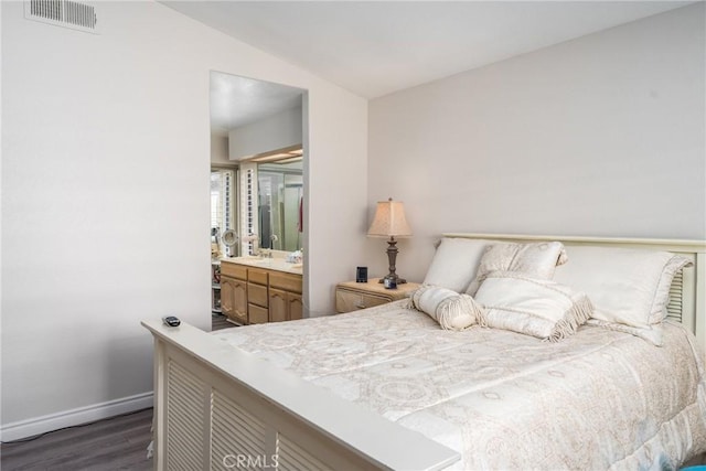 bedroom with dark wood-type flooring, connected bathroom, and vaulted ceiling