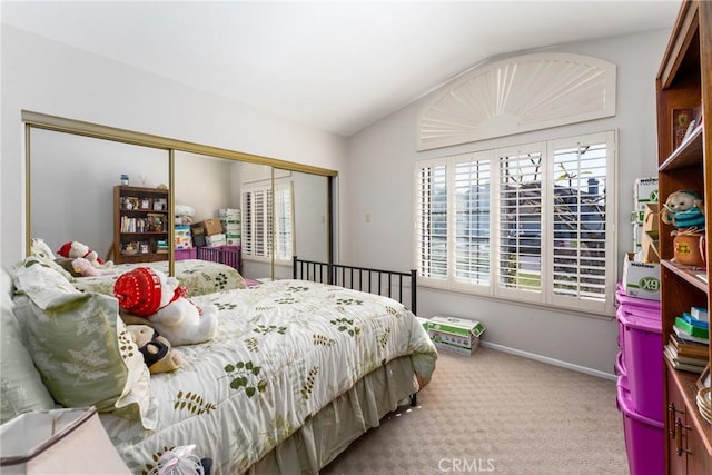 bedroom with vaulted ceiling, light carpet, and a closet