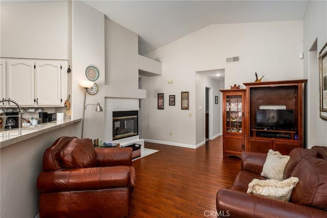 living room featuring dark hardwood / wood-style flooring and high vaulted ceiling