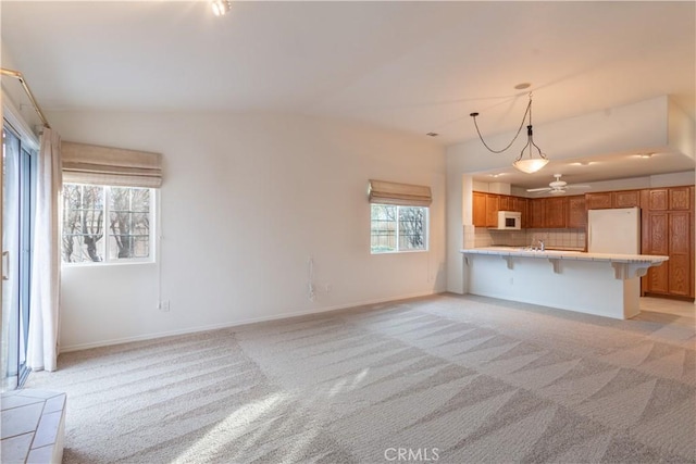 unfurnished living room featuring light colored carpet and vaulted ceiling